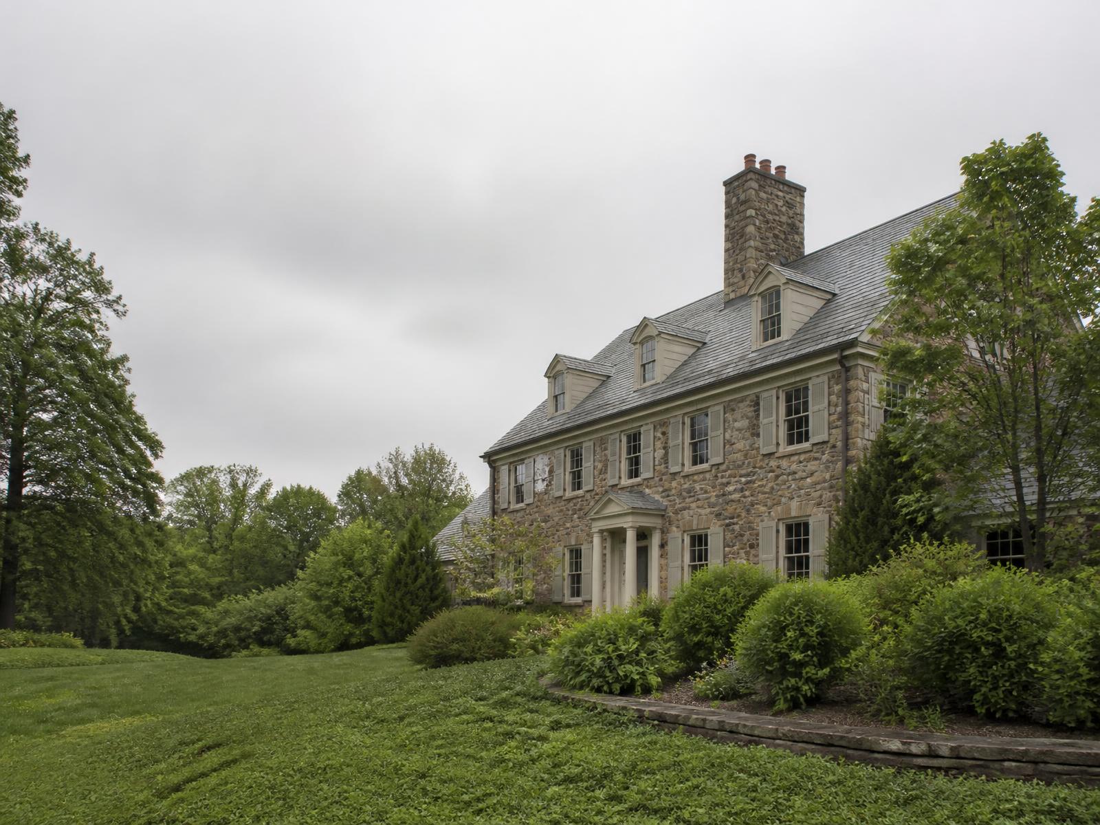 Stone residence surrounded by mature New Jersey landscaping